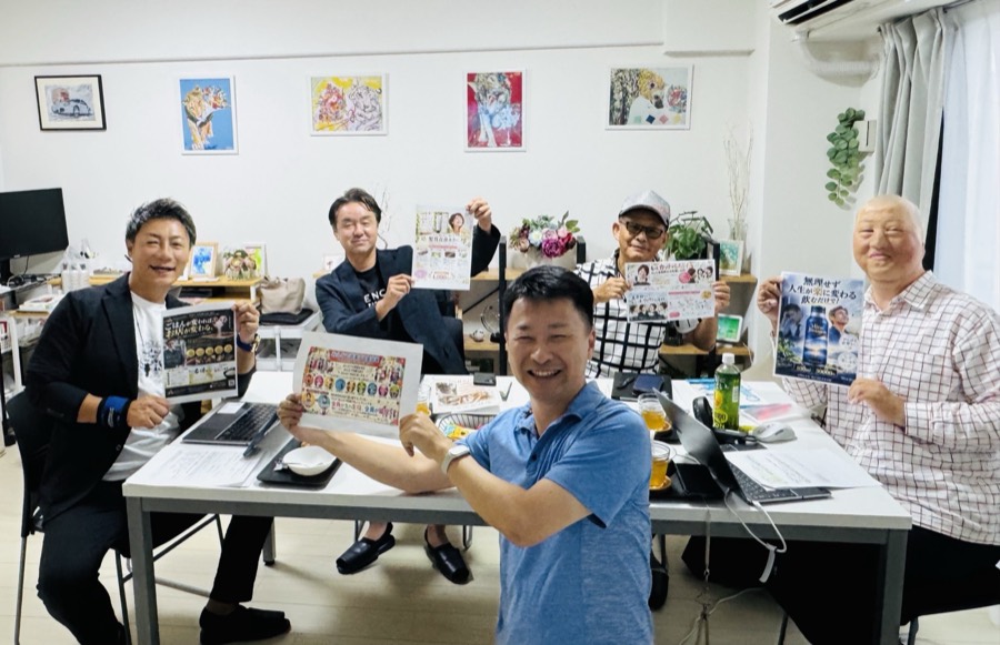 ワークショップ終了時、参加者がそれぞれ完成したチラシを手に持って並んでいる写真