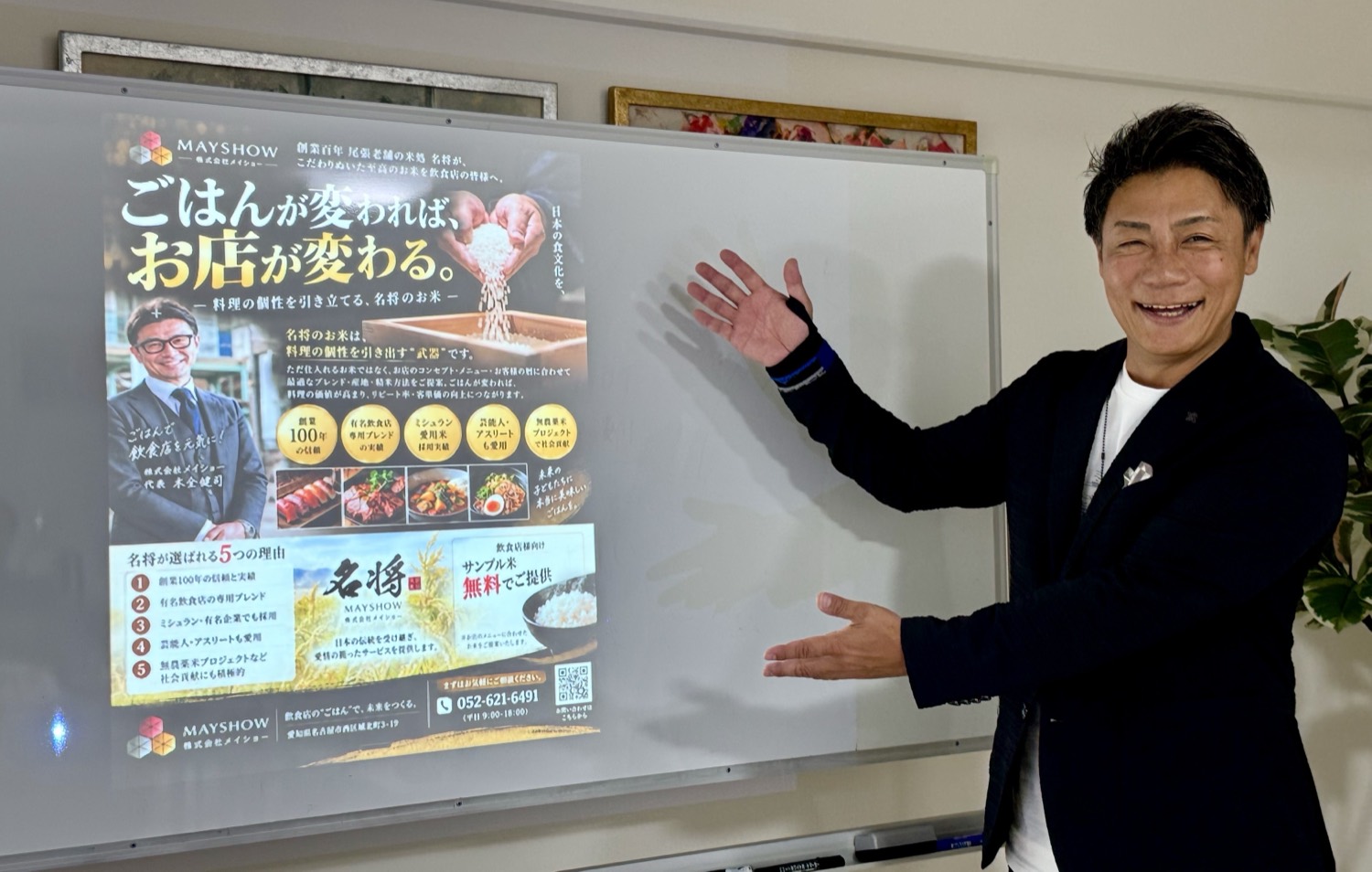 Kさんが、完成した『ごはんが変われば、お店が変わる。』のチラシの前でポーズしている